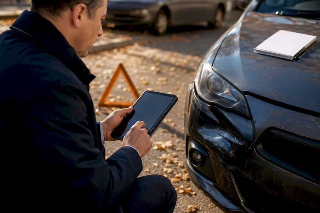 Appraiser inspecting car damage with tablet
